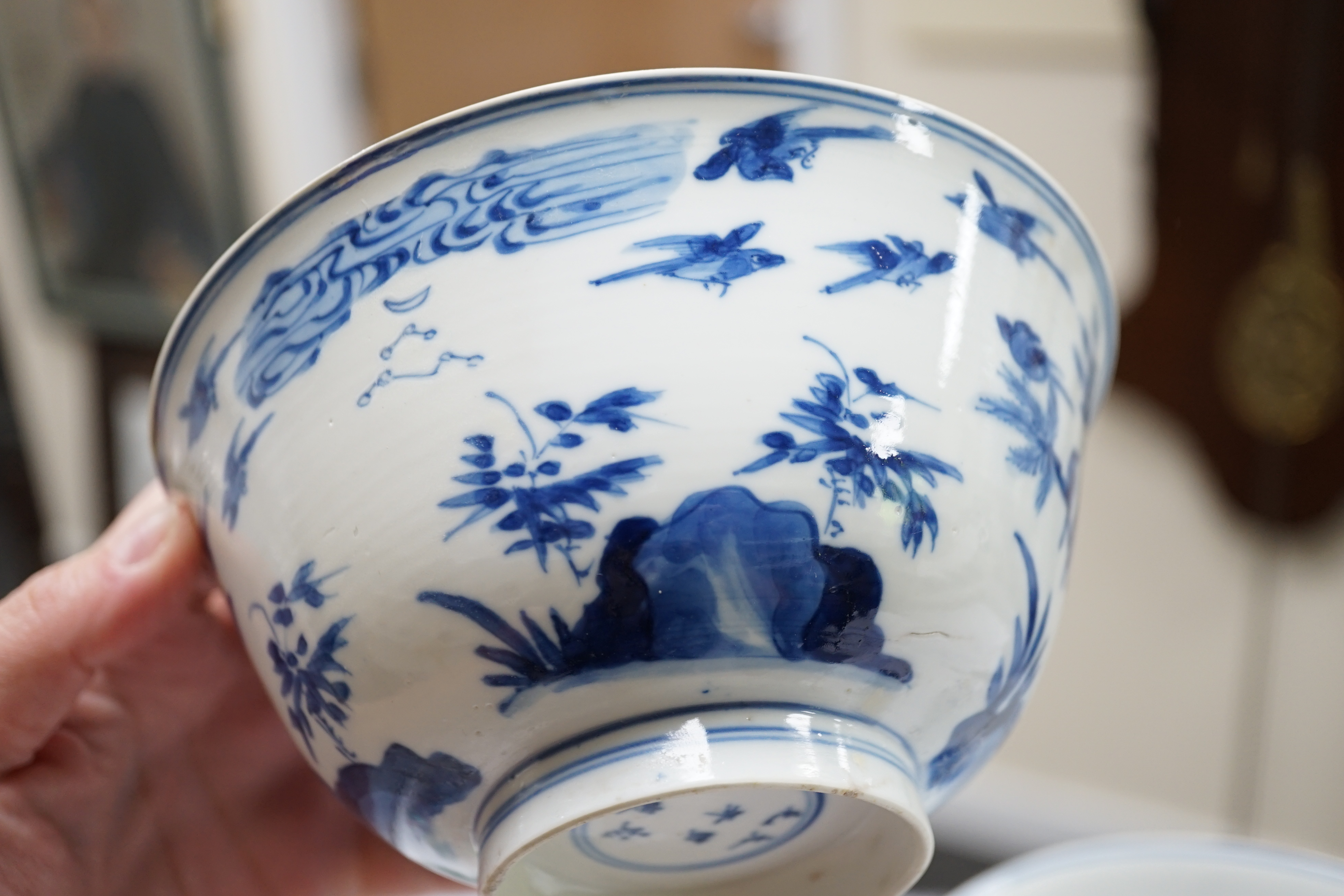 A near pair of Chinese blue and white ‘birds’ bowls, Kangxi period, one bowl restored